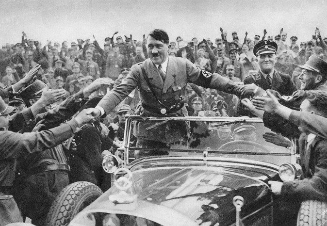 1933: Adolf Hitler, dåvarande rikskansler i Tyskland, välkomnas av sina anhängare i Nürnberg.
