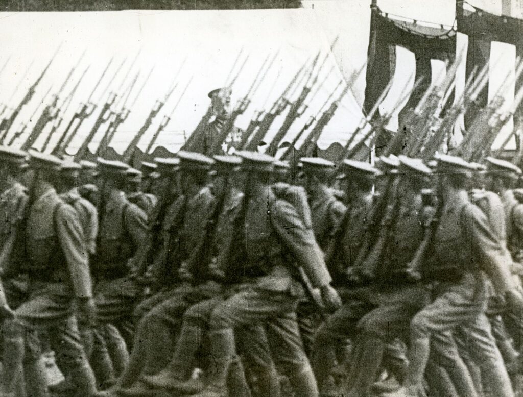 Japanska soldater med gevär och bajonetter marscherar förbi kejsar Hirohito, omkring 1941. 