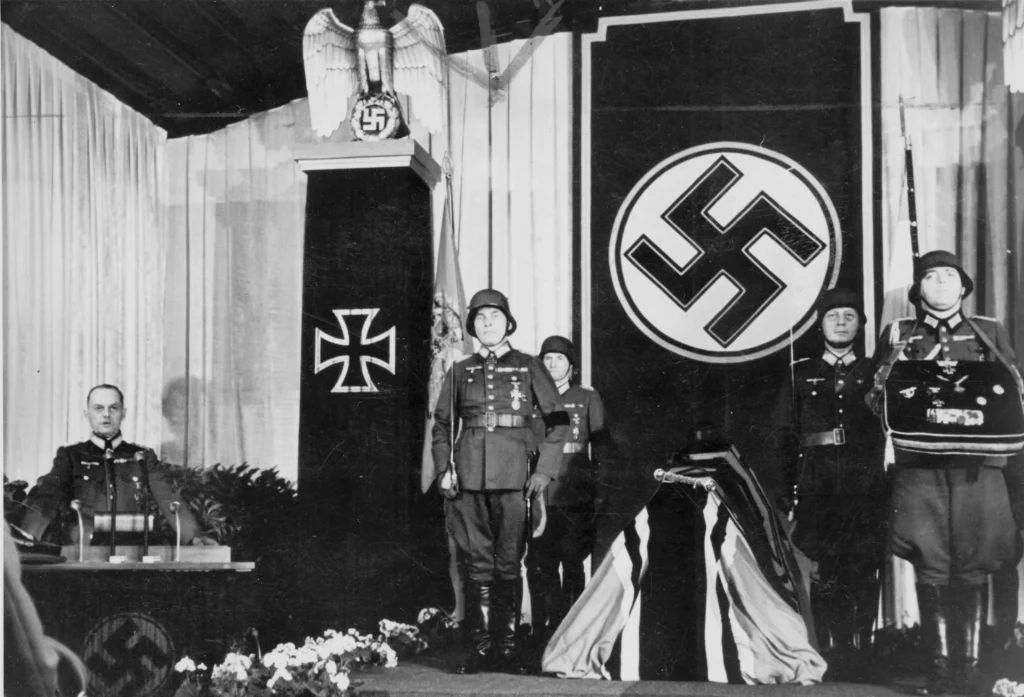 Fältmarskalk Gerd von Rundstedt (till vänster) håller ett tal till Hitlers ära som en hyllning till Rommel vid dennes begravning 1944. 