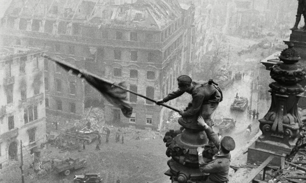 Jevgenij Khaldejs originalbild av den sovjetiska flaggan som hissas över Riksdagshuset i Berlin 1945, ovan, redigerades senare för att dölja officeren som bar klocka på båda handlederna.