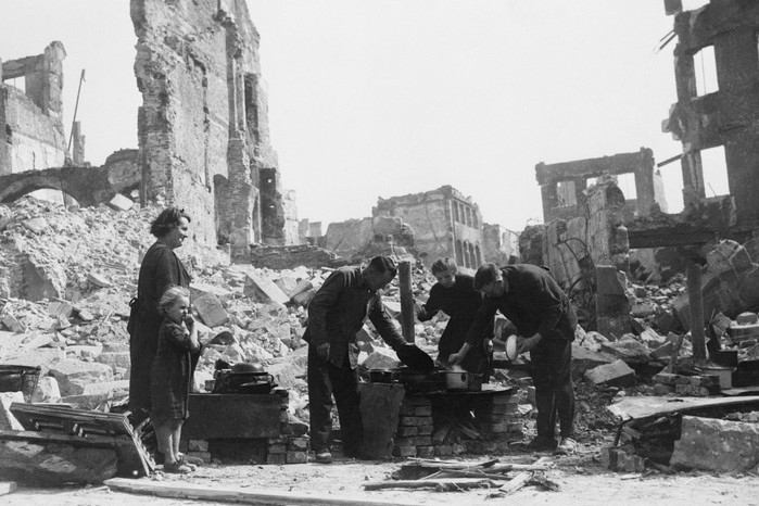 Mitt bland ruinerna i Nürnberg 1945 lagar överlevande mat bland stadens förstörda rester. Nürnberg, som en gång var en symbol för nazisternas makt, låg ödelagt vid krigsslutet. 