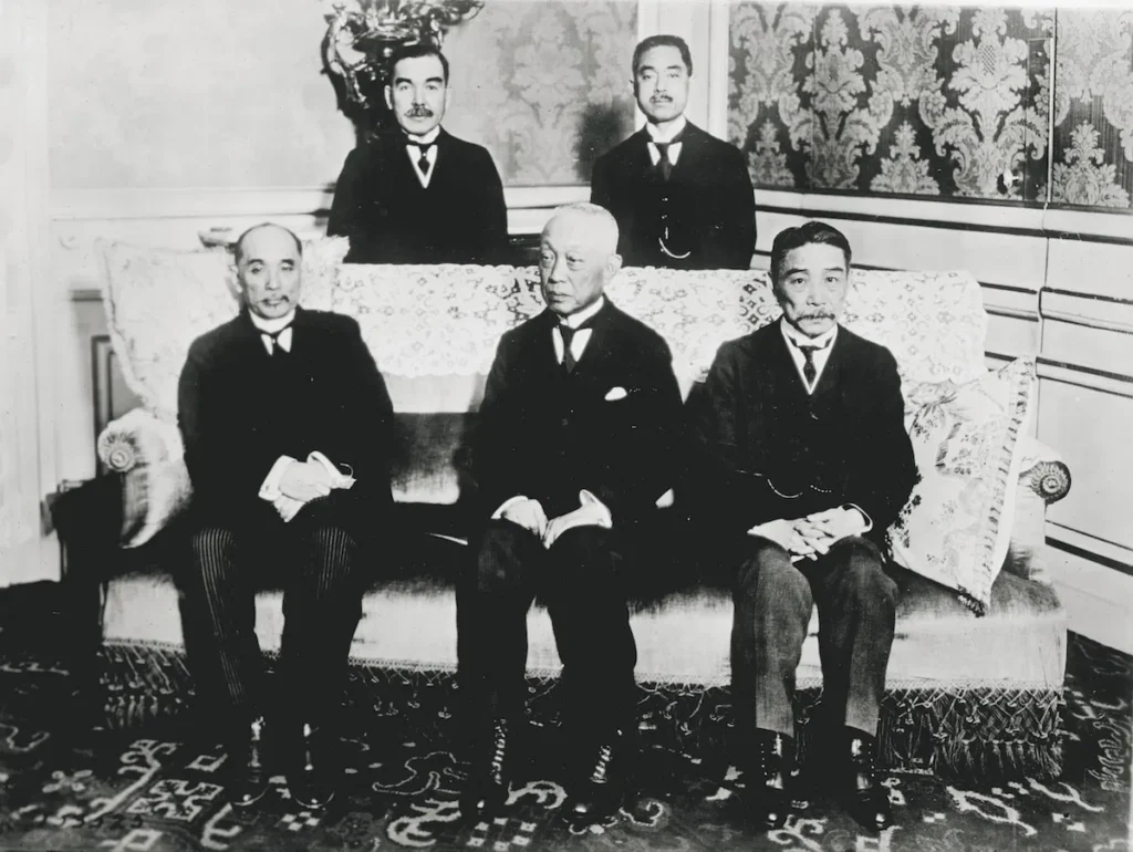 Japanska delegater vid fredskonferensen i Paris 1919. Stående (från vänster till höger): Hikokichi Ijūin och Keishirō Matsui; sittande (från vänster till höger): Baron Makino Nobuaki, prins Kinmochi Saionji och viscount Sutemi Chinda. Library of Congress.